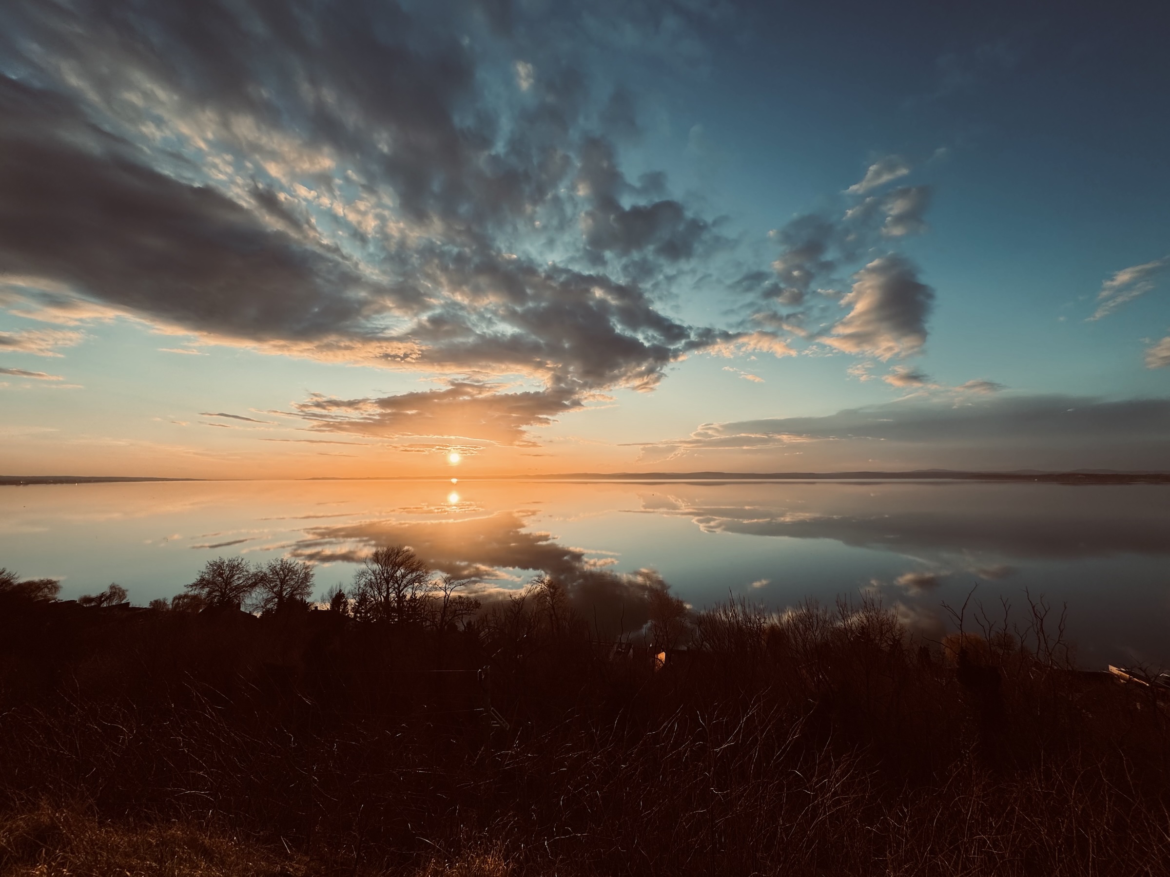 Sunset over Balaton with turquoise water and white sailing boats